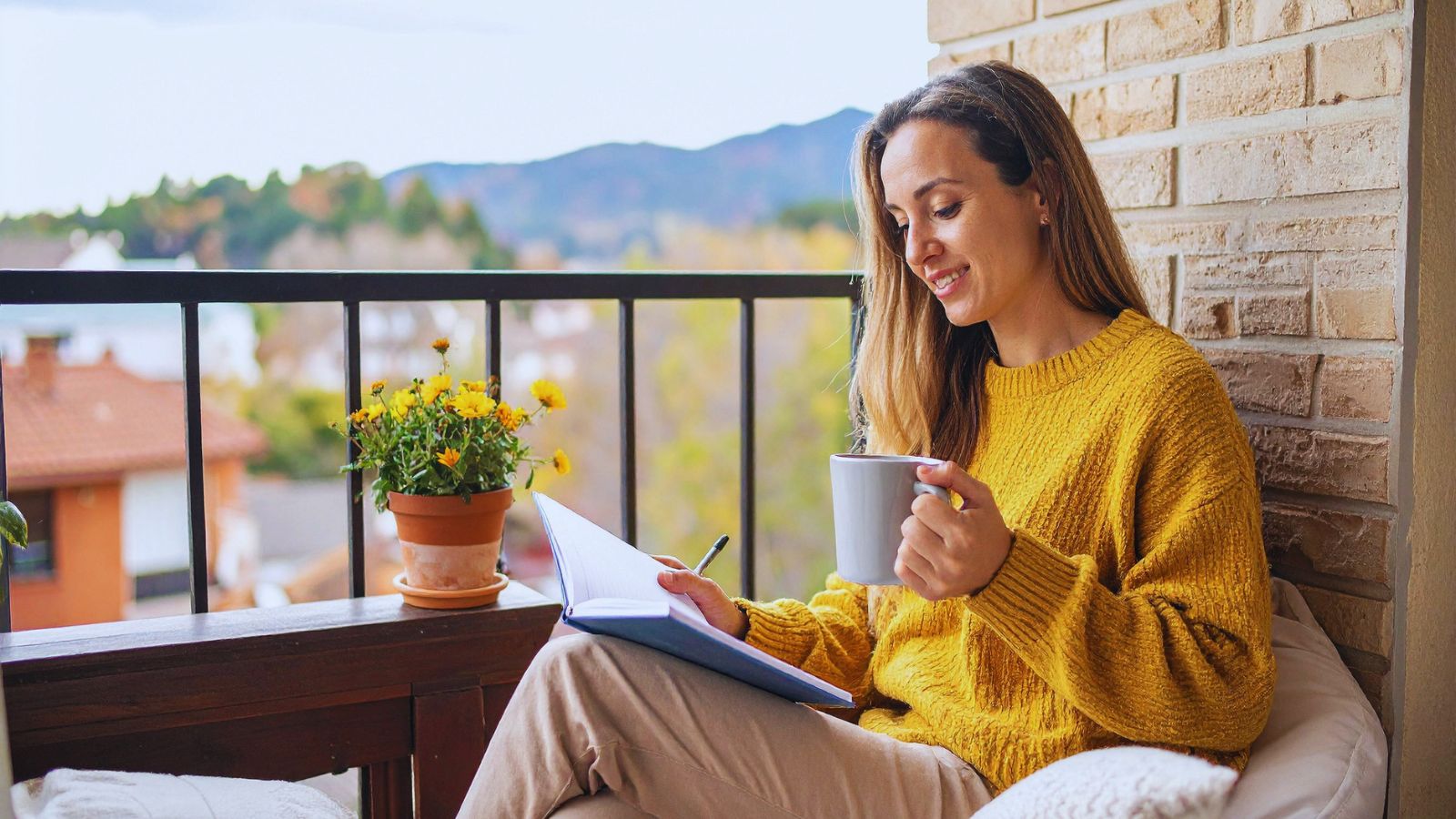 A person on a deck reviewing a journal with handwritten daily entries, in soft natural light.